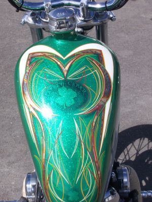 Click to view full size image
 ============== 
widened sporty tank, boat gas cap, green flake, gold leaf, and pinstripe.
